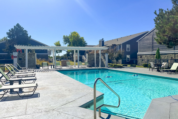 At Windrush, the clubhouse featuring a spacious, sparkling pool flanked by comfortable loungers.
