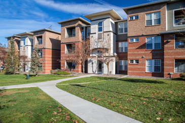 Exterior view of Bristol Village apartments in Aurora, Co with a large lawn in front