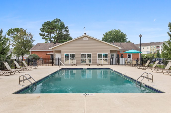 A spacious pool area positioned in front of the clubhouse at Spring Hill in Nashville, Tennessee, providing residents with a serene outdoor oasis for relaxation and recreation.
